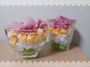 枝豆、ご飯、炒り卵、ハムがカップに入ったちらし寿司の写真